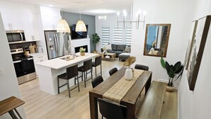 A modern kitchen with white cabinets, stainless steel appliances, and a central island. - BoHo Modern Retreat w/King|Fireplace|Disney+ (Edmonton)