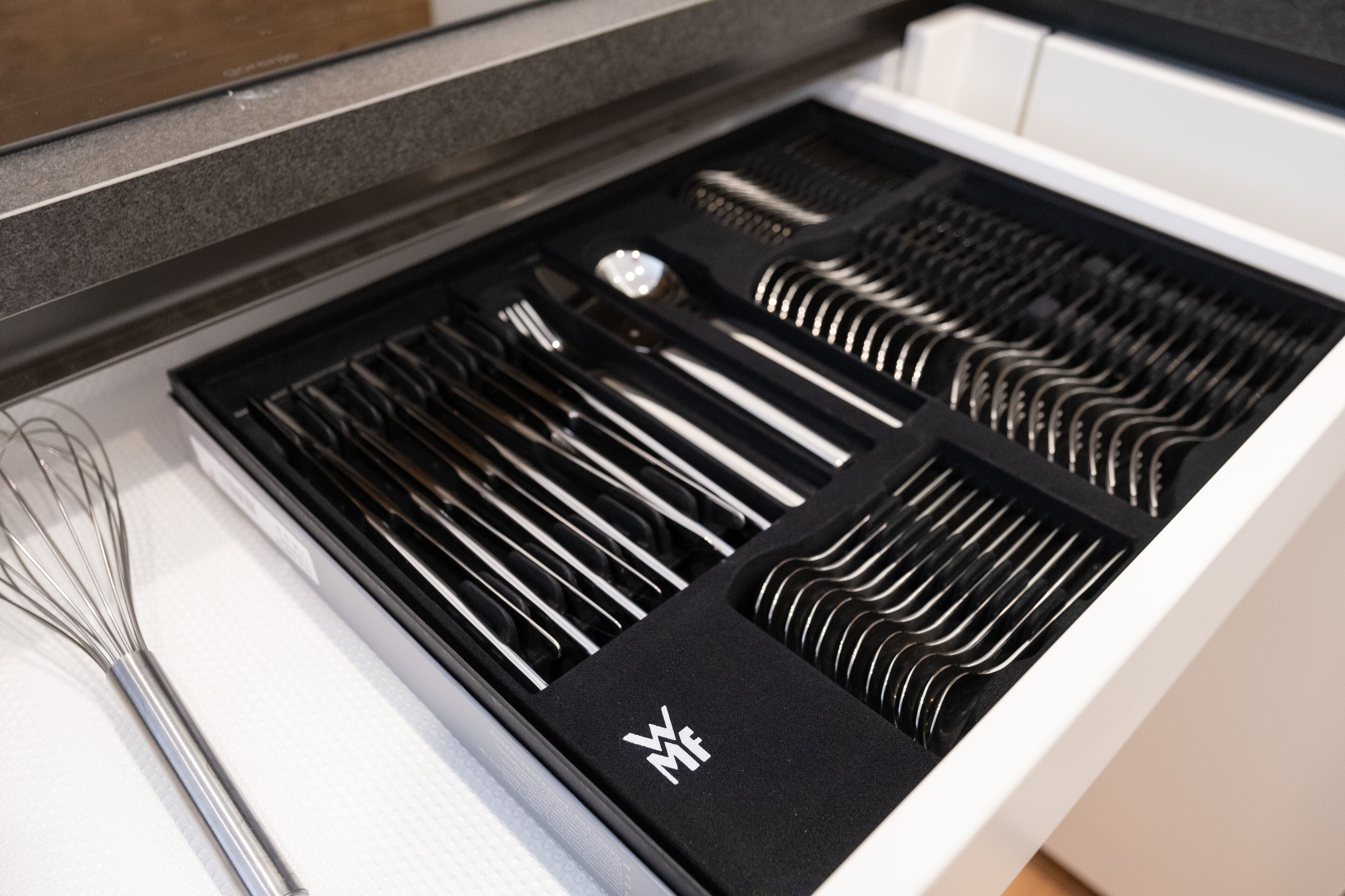 Un cassetto della cucina con vari utensili disposti in ordine.