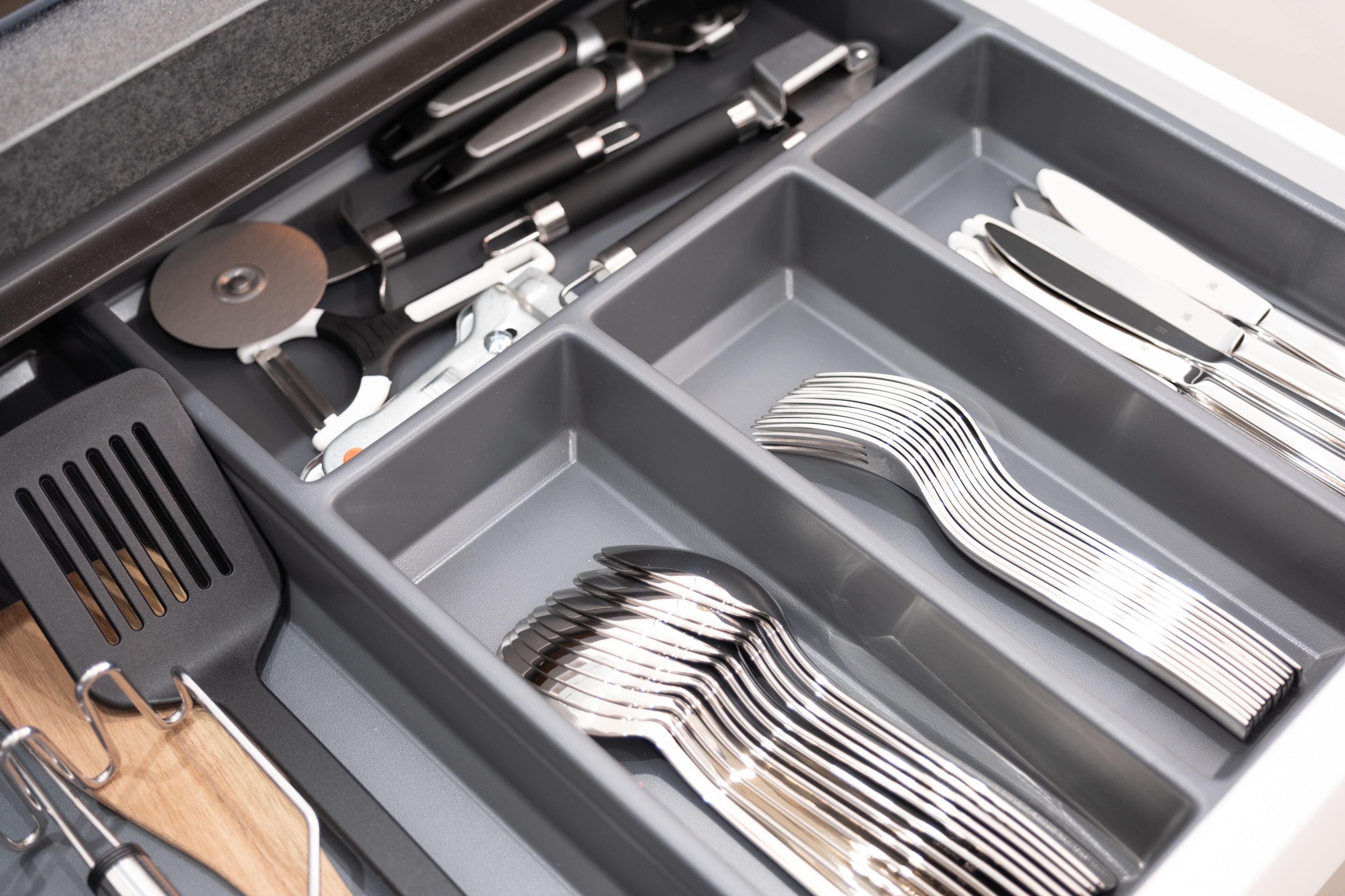 A kitchen drawer with utensils and tools.