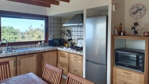 A kitchen with wooden cabinets, a gas stove, a microwave, a refrigerator, and a built-in oven. - Finca Vista al Teide with private swimmingpool and jacuzzi, Wifi and Sat TV (Santa Úrsula)