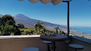 A terrace with a table and two chairs, overlooking a cityscape and a mountain. - Finca Vista al Teide with private swimmingpool and jacuzzi, Wifi and Sat TV (Santa Úrsula)