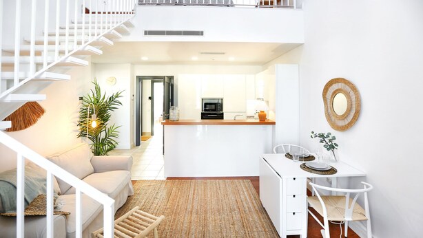Un appartement moderne comprenant un escalier, une cuisine, un coin repas et un salon.