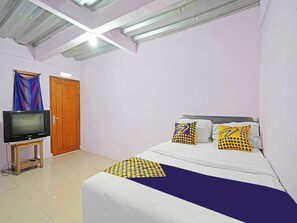 A bedroom with a bed, a television on a small table, and a door. - Hotel O Biring Residence (Wargasaluyu)