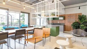 Un ufficio moderno con zona pranzo, cucina e diverse postazioni di seduta.