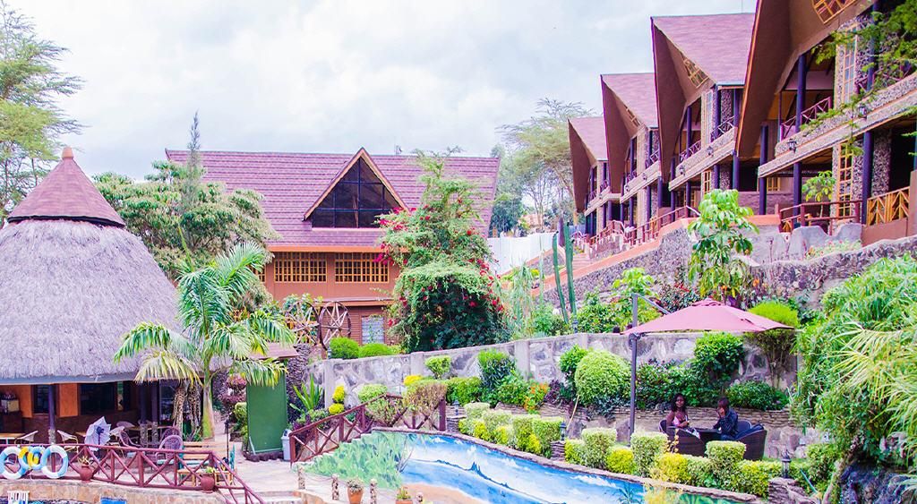 A resort with a pool, thatched-roof structures, and a landscaped garden.