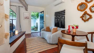 A cozy living area with a sofa, a dining table, and a rug.