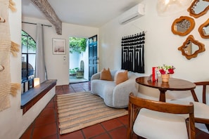 A cozy living area with a sofa, a dining table, and a rug. - Charming Studio Hideaway in Montecito (Montecito)