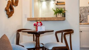 A dining area with a round table, two chairs, a mirror above, and a small potted plant. - Charming Studio Hideaway in Montecito (Montecito)