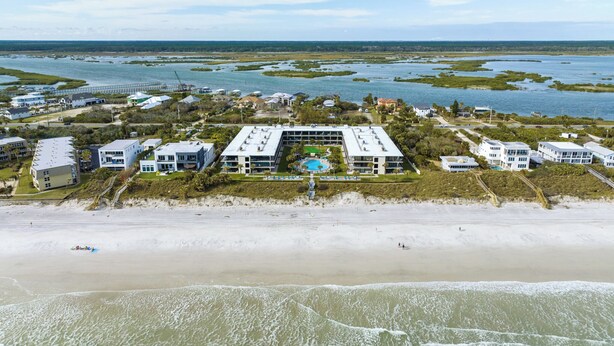 An aerial view of a coastal hotel with multiple buildings, a swimming pool, and a beach. - Ocean House 311 by Distinctive Beach Rentals (St. Augustine)