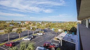 A parking lot with several cars, palm trees, and a view of the ocean. - Ocean House 311 by Distinctive Beach Rentals (St. Augustine)