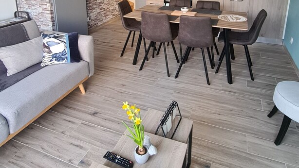 Una sala de estar moderna con un sofá, una mesa de centro y un comedor con sillas y una mesa.