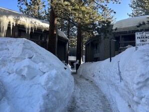 A snow-covered path between buildings with a 'Parking Only' sign. - Mammoth Awesome Location-1 min to Shuttles & Food TOML-CPAN-11402 (Mammoth Lakes)