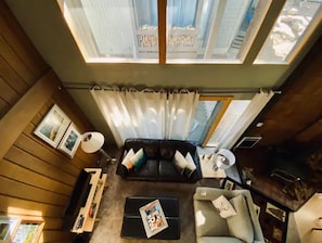 A high-ceilinged living room with a black leather sofa, a coffee table, and a TV stand. - Mammoth Awesome Location-1 min to Shuttles & Food TOML-CPAN-11402 (Mammoth Lakes)