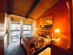 Relax in this serene bedroom with a plush bed, bedside lamps, and a beautiful landscape painting.