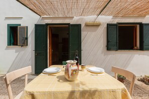 An outdoor dining area with a table set for two, a decorative pitcher, and a bottle of wine. - 2378 Villetta Elia - Casa Cicia by Barbarhouse (Morciano di Leuca)