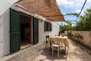 A small house with a patio, a table with chairs, and a door open to the inside. - 2378 Villetta Elia - Casa Cicia by Barbarhouse (Morciano di Leuca)