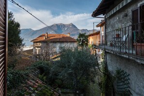 A rustic building with a balcony overlooking a mountainous landscape. - Loppia Bay by Wonderful Italy (Bellagio)