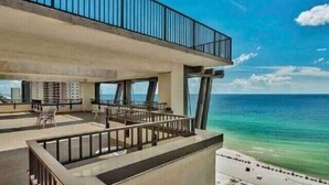 Un edificio moderno con balcón con vistas a la playa.