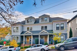 A two-story townhouse with a front porch, a garage, and a stop sign visible. - Walkable Portland Studio < 1 Mi to Dtwn! (Portland)
