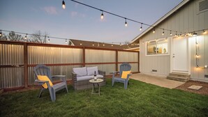 An outdoor patio with two chairs, a small table, and string lights. - 2 BD/1 BA Home- Wine Country Getaway (Santa Rosa)