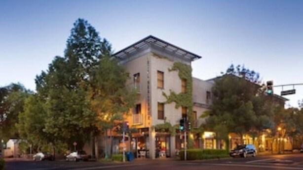 A building with a flat roof, large windows, and a corner location with trees. - 2 BD/1 BA Home- Wine Country Getaway (Santa Rosa)