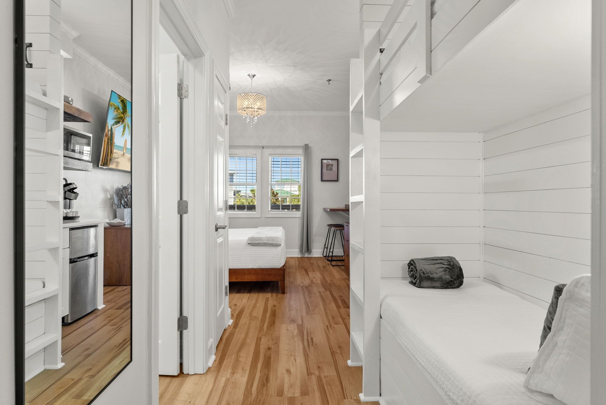 Une chambre moderne avec un plancher en bois, un lit, une table de chevet et une fenêtre donnant sur l’extérieur.