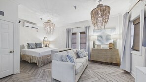Une chambre d’hôtel avec un lit, un canapé, un bureau et un lustre.