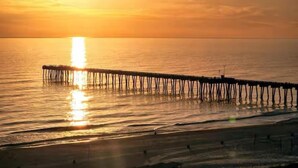 Un muelle se adentra en aguas tranquilas durante el atardecer.