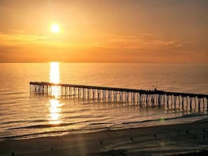 Un muelle se adentra en aguas tranquilas durante el atardecer.