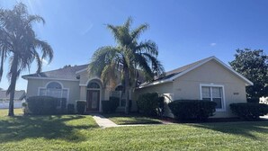 Una casa a un piano con un ingresso principale, un garage e un prato curato.