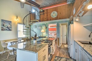 Enjoy cooking in this well-equipped kitchen with a central island, stove, and ample counter space.