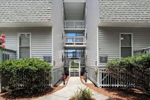 Stunning two-story residence with a central staircase and balcony, featuring a symmetrical facade with evenly spaced windows.