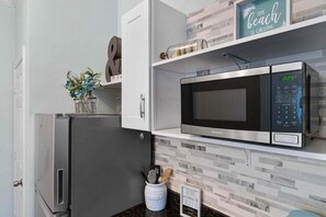 A kitchen with a stainless steel refrigerator, a microwave, and a coffee maker on the countertop.