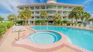 A hotel with a pool area, including lounge chairs and a hot tub. - Beach Happy 100-steps to beach-Sleeps 2 (Seacrest)