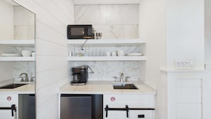 A modern kitchen with white marble countertops, a built-in microwave, a coffee maker, and a dishwasher. - Dragana's Paradise 30A 410-Pool-Sleeps 2 (Seacrest Beach)