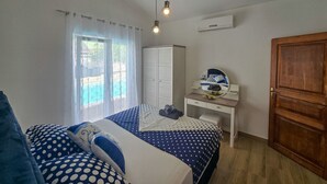 A bedroom with two beds, a desk with a mirror, and a wardrobe. - House Of Good Vibrations Indy (Galizana)