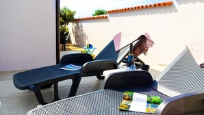 A patio with two lounge chairs, a small table, and a bottle of champagne. - House Of Good Vibrations Indy (Galizana)