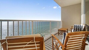 Ein Balkon mit Holzmöbeln und Blick auf den Ozean.