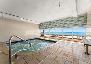 Ein Wellnessbereich mit Whirlpool, Blick auf den Strand und Fliesenboden.