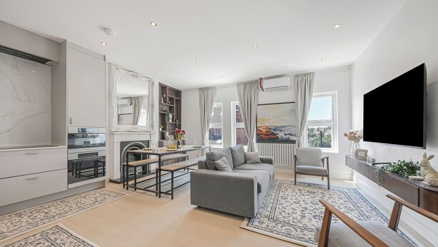 A modern living room with a sofa, TV, and dining area. - Oversize 3Bed 2bath Victorian Penthouse w/ AC in Maida Vale (London)