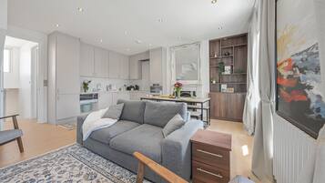 A modern living room with a grey sofa, wooden coffee table, and a patterned rug.
