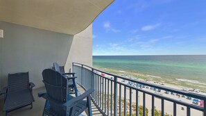 A balcony with a view of the beach and ocean.