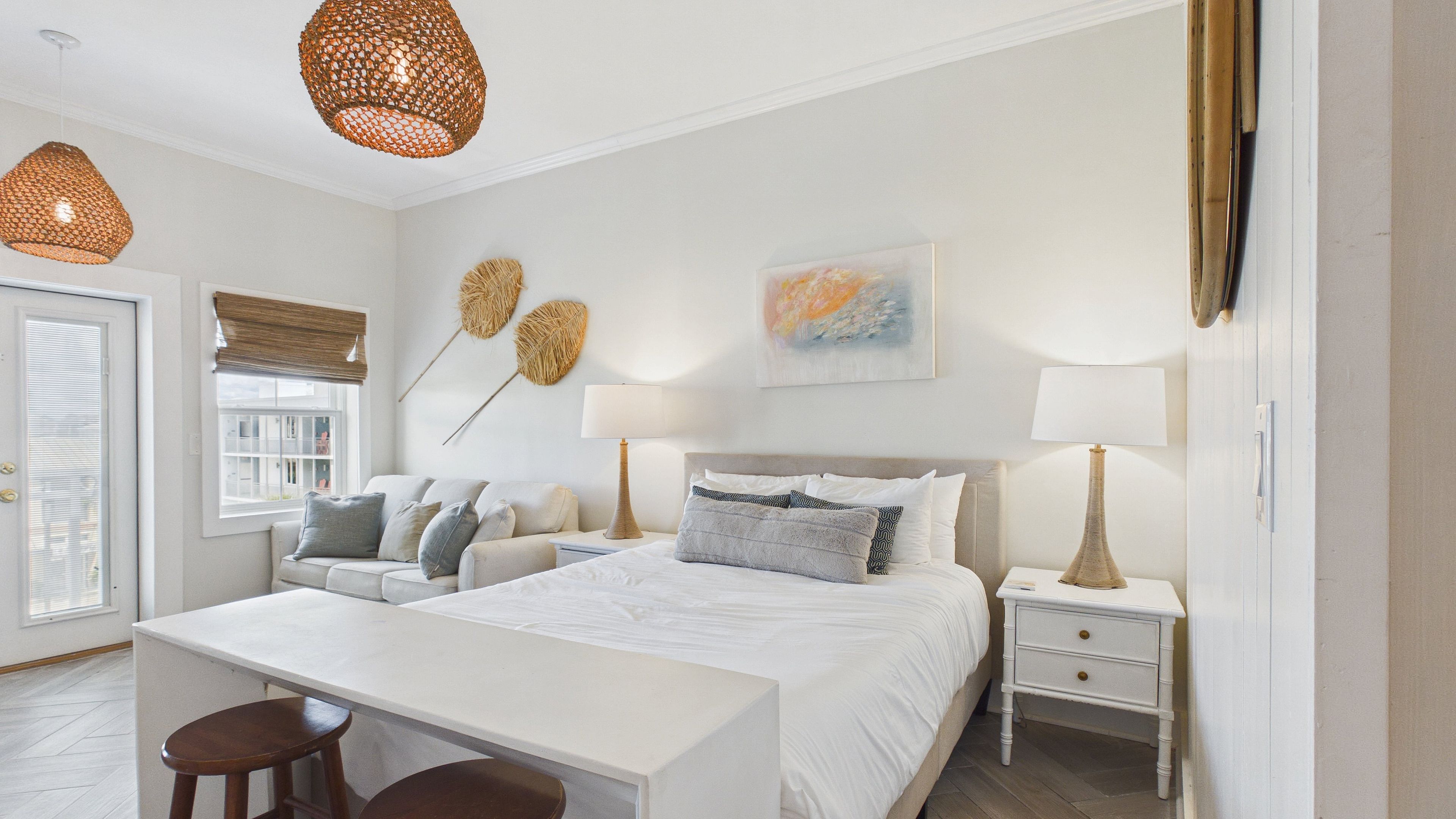 A modern bedroom with a bed, bedside tables, a desk, and a chair.