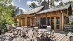 A wooden deck with outdoor furniture, including tables and chairs. - Sea Garden 3205-Near Beach-Sleeps 4 (Miramar Beach)