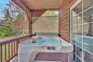 A hot tub on a wooden deck with a view of trees and a house. - The Retreat at Rockridge ( HotTub )  (Pipestem)