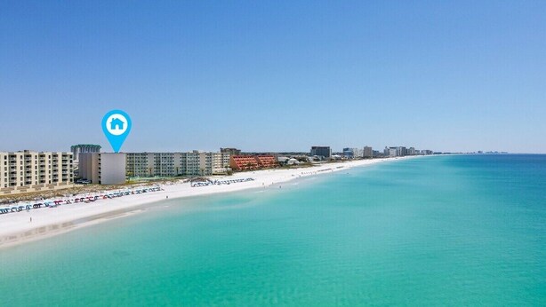Ett hotell vid kusten med utsikt över stranden, flera våningar och en tydlig blå markering på kartan.