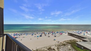 Une plage avec de nombreux parasols et beaucoup de baigneurs.