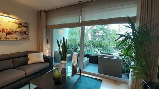 A modern living room with a sofa, a coffee table, and a large window offering a view of the outdoors. - Very nice apartment downtown, Parc Olympe de Gouges ( with garage) (Annemasse)