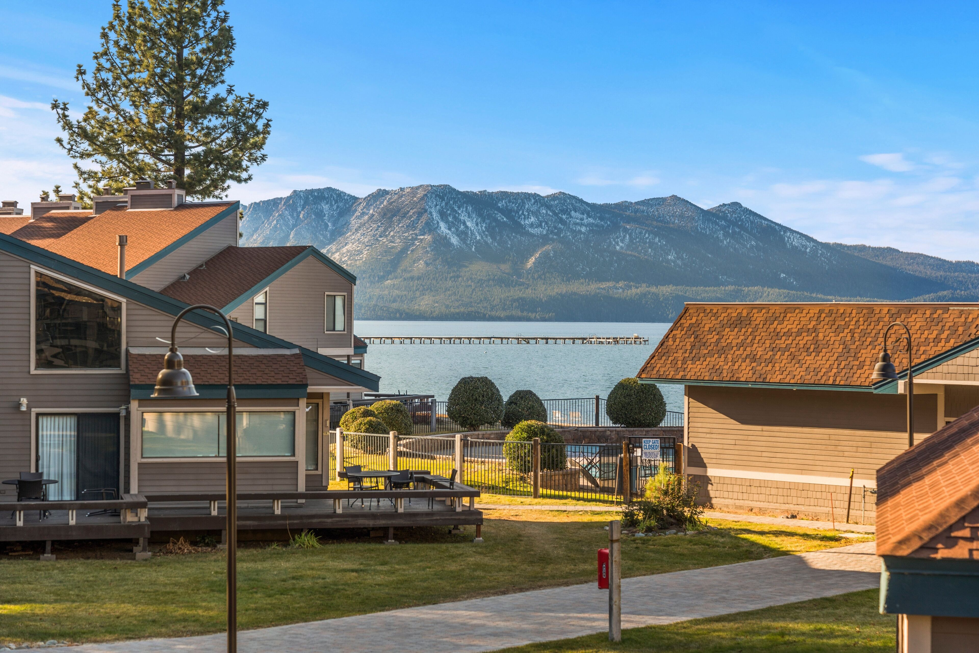 A residential area with houses, a dock, and a mountain backdrop.