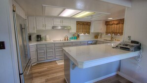 Una cocina con armarios blancos, una isla grande y un horno empotrado.